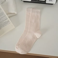 Pale pink slouch socks with wavy vertical knit texture displayed on a white desk - One Size / Pink