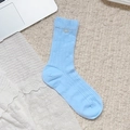 Light blue mid-calf socks with ribbed texture and delicate bow detail on carpet - Pearl Bowknot