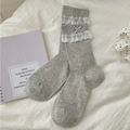 Süße hellgraue Baumwollsocken mit weißer Spitze und zarter blauer Schleife im Detail - Grau