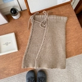 Oatmeal knit leg warmers with drawstring ties and cable stitch detail on wood surface - One Size / Light Coffee