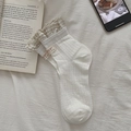 Beige knit lace socks with plaid ruffle trim and heart tag in a minimalist setting - White / One Size