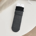 Calze medie grigio scuro con bordo nero a volant e polsini elastici a coste su fondo bianco - Taglia unica / grigio scuro