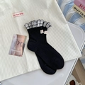 Sweet black crew socks with checkered ruffle trim and heart tag on white background - One Size / Black