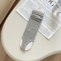 Grey knit stirrup leg warmers with ribbed texture in a stylish lifestyle setting - Light Gray
