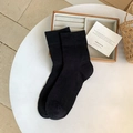 Atmungsaktive schwarze hohlgestrickte Socken mit Rippbündchen auf weißem minimalistischem Tisch - Einheitsgröße / Schwarz