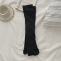 Dark gray tabi split toe socks in long ribbed knit style on a cozy white bed background - Dark Gray