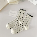 Creamy white crew socks with black heart patterns and elegant ruffle edges - Heart