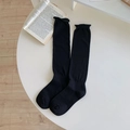 Calcetines negros altos con bordes rizados presentados en una mesa blanca - Talla única / Negro