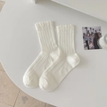 White crew socks with vertical ribbing and delicate ruffle cuffs for a minimalist look - White