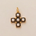 Macro detail of golden cross pendant featuring white pearls and black gemstones - Five White Pearl Cross