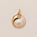 Detailed close-up of Yin Yang pendant in gold-polished metal and white enamel finish - White Yin Yang