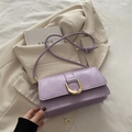 Elegant purple PU leather crossbody bag with golden buckle on white fabric and blazer - Purple
