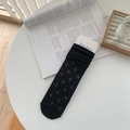 Ballet style black hollow mesh mid-calf socks with floral patterns on white table - One Size / Black