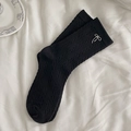 Black knit crew socks featuring silver metal bow charms and a classic cable pattern - One Size / Black