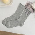 Mid-calf gray knit socks featuring hollow dot patterns and decorative satin bows - One Size / Gray