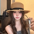Detail of straw sun hat with black bow and frayed edges worn by a model in a cafe - Khaki Raw Edge Straw Hat (D-322)