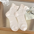 Creamy white crew socks with ruffle cuffs and hollow mesh knit patterns on glass surface - Pink