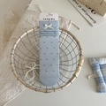 Light blue crew socks with black polka dots and white bow detail in a gift basket - Light Blue Polka Dot Bow