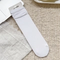 Chaussettes en velours côtelé blanc avec emballage papier sur fond en peluche beige doux - Taille unique / Blanc Pur