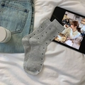 Graue gerippte Socken mit schwarzen Punkten in einer Lifestyle-Szene präsentiert - Einheitsgröße / Grau