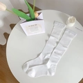 White ballet style ribbed knee-high socks in a clean minimalist aesthetic setup - White