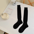 Calcetines altos negros clásicos de algodón con tejido acanalado sobre fondo blanco - Talla única / Negro
