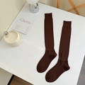 Dark brown knee-high socks with ribbed cuffs in a minimalist lifestyle setting - One Size / Coffee
