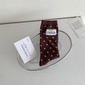 Chaussettes mi-mollet marron foncé à pois blancs et étiquette en tissu dans un panier - Taille unique / Café