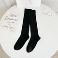 Knee-high black ribbed socks with elastic wide cuffs shown on minimalist white background - One Size / Black