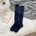 Knee high navy blue knitted socks with vertical stripes in a cozy winter setting - Dark Blue