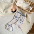 Wollsocken für den Winter mit blauen Skifahrern und Bergmustern auf Creme-Strick - Cremeweiß Ski