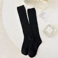 Jambières classiques noires en tricot côtelé sur table avec décor style de vie épuré - Taille unique / Noir