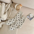 Calze medie in maglia beige con motivi a cuori neri in un ambiente domestico accogliente - Beige