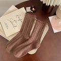 Brown thick rib knit wool socks with ruffle cuffs on vintage wooden table - Coffee