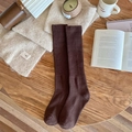 Deep brown long socks with thick ribbed knit texture on a cozy winter themed wooden table - One Size / Coffee