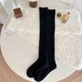 Thick black over-the-knee cashmere socks in a cozy minimalist home setting - One Size / Black