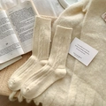Calze spesse in lana a trecce color crema da donna in un accogliente ambiente - Beige