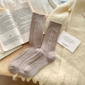 Cozy beige cable-knit wool socks for women in soft oatmeal color on warm blanket - Light Coffee