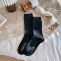 Thick black wool thermal socks with ribbed knitting in a cozy aesthetic lifestyle setting - Black