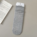 Heather gray knitted mid-calf cotton socks with minimalist brand tag on gray background - Light Gray