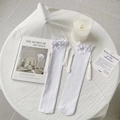 White knee-high socks featuring delicate lace flowers and long tassel accents - One Size / White