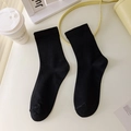 Classic black cotton crew socks with ribbed cuffs on a clean minimalist desk - Black