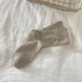 Beige ribbed crew socks with ruffle edges and colorful flecks on a soft fabric background - Khaki