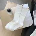 White ribbed crew socks with a heart fabric label on minimalist silver tray background - White