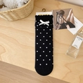 Chaussettes mi-mollet noires à pois blancs et détail de nœud sur surface en bois - Noir avec Blanc