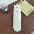 Calze a coste color panna con ricamo a fiocco marrone su un tavolo di legno scuro - Bianco