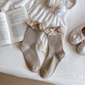 Light coffee knit crew socks featuring elegant lace trim and ribbon bow accents - One Size / Khaki
