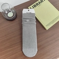 Calze grigie a coste medie con ricamo a fiocco bianco su sfondo in legno scuro - Grigio chiaro