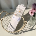 White sheer tulle socks with colorful daisy embroidery on original cardboard packaging - One Size / Gray