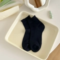 Short black socks with ruffled edges and fine ribbed texture for women on tray - One Size / Black